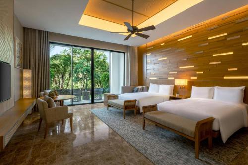 une chambre d'hôtel avec deux lits et une grande fenêtre dans l'établissement JW Marriott Cam Ranh Bay Resort & Spa, à Cam Ranh