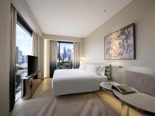 シンガポールにあるMondrian Singapore Duxtonの白いベッドと大きな窓のある寝室