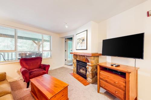 a living room with a fireplace and a flat screen tv at Town Plaza, Unit 209 in Whistler