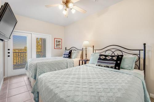 a bedroom with two beds and a flat screen tv at The Village at Gruene - Unit 201 in Gruene