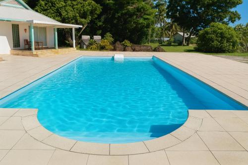 a swimming pool with blue water in a yard at Hotel Albatros Wallis 