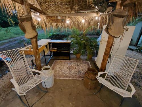 two white chairs and a table in a room at Morada Gaia in Tempate