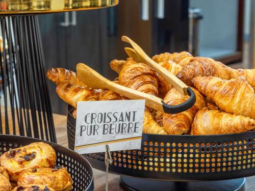 Una cesta de croissants y pasteles sobre una mesa en Mercure Singapore Tyrwhitt, en Singapur