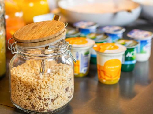 un frasco de cacahuetes sentado en una mesa con otros alimentos en Mercure Singapore Tyrwhitt, en Singapur