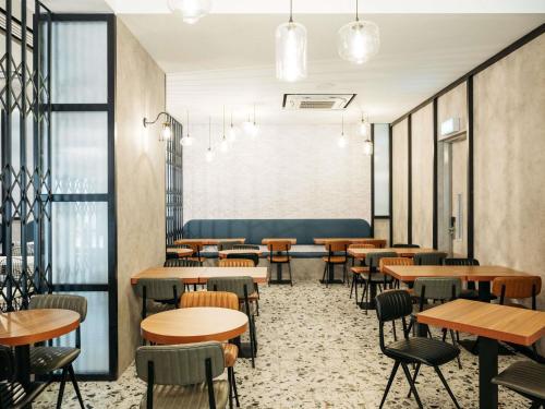 un comedor con mesas y sillas en Mercure Singapore Tyrwhitt, en Singapur