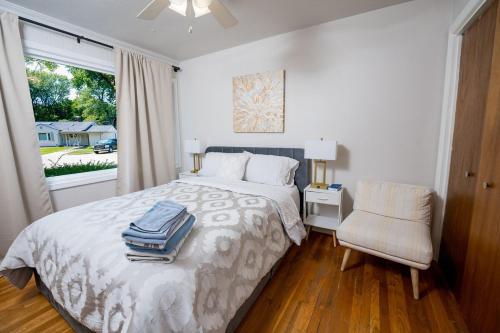 a bedroom with a bed and a chair and a window at Entire home, 6 min drive to UIUC in Champaign