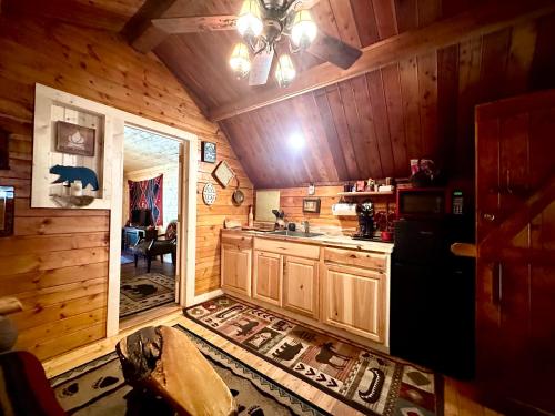 a kitchen with a refrigerator and a sink in a cabin at Big Bear Log cabin in Cosby