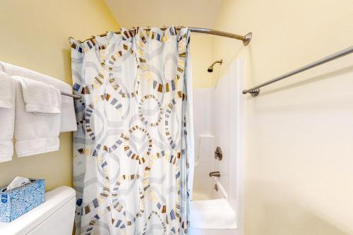 a bathroom with a shower curtain next to a toilet at The Colonels Suites #4 in Northeast Harbor