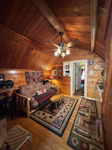 a living room with a couch and a ceiling fan at Big Bear Log cabin in Cosby