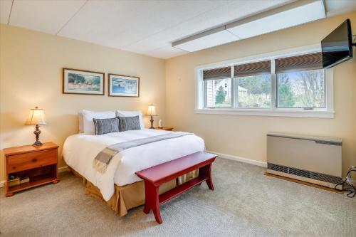 a bedroom with a large bed and a flat screen tv at Lodge Condo 26 in Stowe
