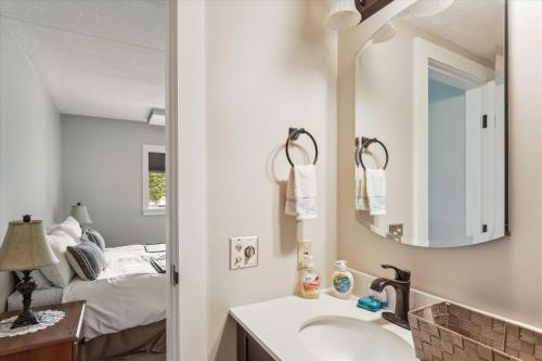 a bathroom with a sink and a mirror and a bed at Lodge Condo 26 in Stowe