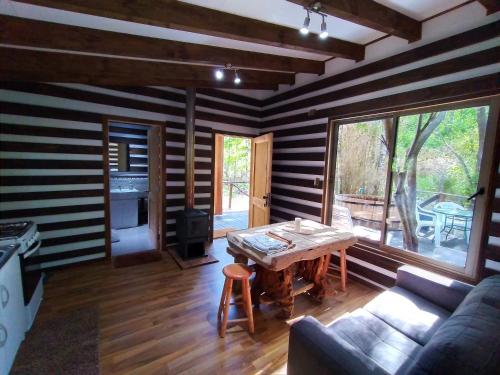 a living room with a table and a couch at Domos Conguillío - Cabaña en el bosque in Melipeuco