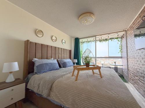 a bedroom with a bed with a wooden headboard and a table at Nuevo departamento con vista al mar y piscina-Pool One in Lima