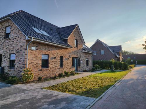 a brick house with a black roof at Habbo's Kojen in Neuharlingersiel
