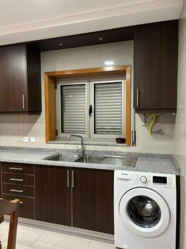 EstelaにあるCasa Gomesのシンクと洗濯機付きのキッチン