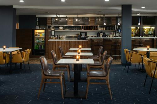 a restaurant with tables and chairs and a bar at Courtyard Texarkana in Texarkana