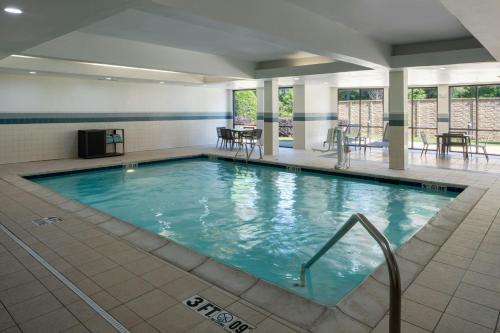 a large swimming pool with blue water in a building at Courtyard Texarkana in Texarkana