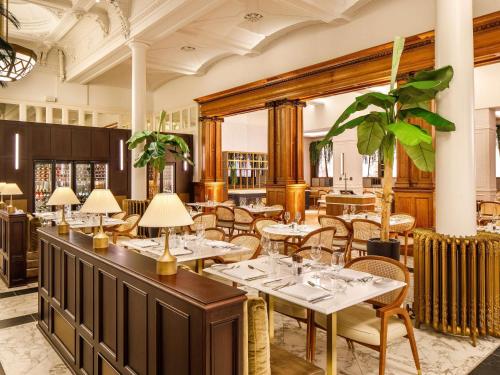 a restaurant with tables and chairs in a room at The Municipal Hotel Liverpool - MGallery in Liverpool