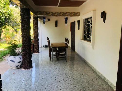 a patio with a table and chairs and a vase at Princess Eco Lodge & Garden in Kartung