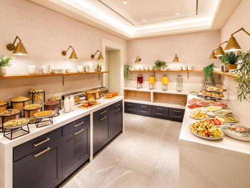 a large kitchen with many plates of food on the counter at The Municipal Hotel Liverpool - MGallery in Liverpool