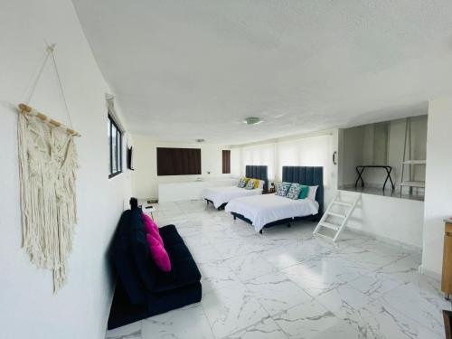 a large room with two beds and a couch at Hotel Bungalows Casa Blanca in Tenancingo de Degollado