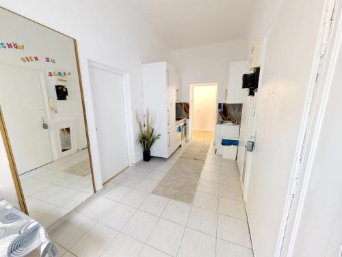 a hallway with white walls and a mirror at Comfortable Rooms in Wiener Stadthalle area G4 in Vienna