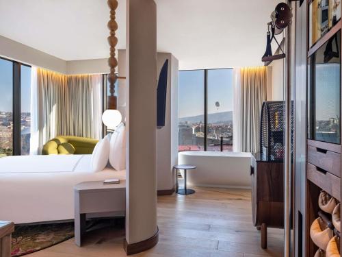 a hotel room with a bed and a bath tub at Swissôtel Tbilisi in Tbilisi City