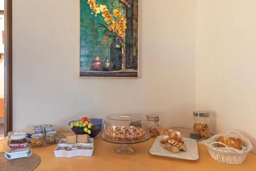 een tafel met eten en een schilderij aan de muur bij Country House Binnella in Cingoli