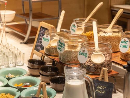 una mesa con tarros de comida y tazones de comida en Novotel Jodhpur ITI Circle, en Jodhpur