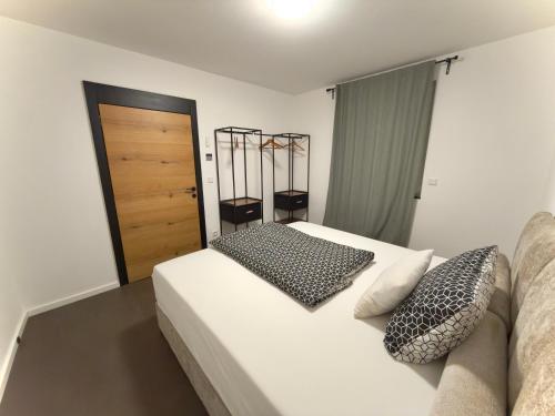 een slaapkamer met een wit bed en een houten deur bij Ferienwohnung in der Grafschaft- Nähe Bonn, Ahrtal 