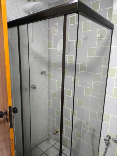 a shower with glass doors in a bathroom at Flat praia Vila Velha ES in Vila Velha