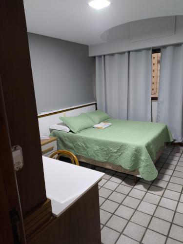 a small room with a bed and a window at Flat praia Vila Velha ES in Vila Velha
