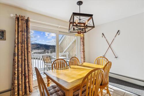 a dining room with a table and chairs and a window at Mountainside Condo J201 in Stowe