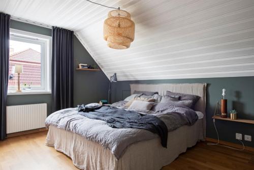 a bedroom with a large bed with a white ceiling at Modern Swedish villa in Hagby