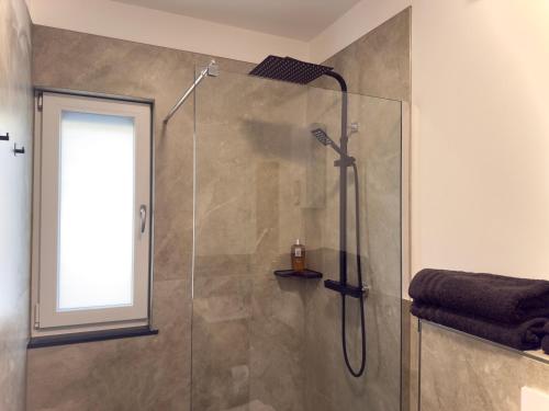 een badkamer met een douche met een glazen deur bij Ferienwohnung in der Grafschaft- Nähe Bonn, Ahrtal 