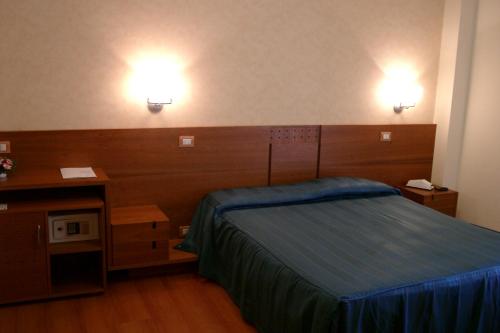 a bedroom with a bed and two lights on the wall at Hotel Gala in Pesaro