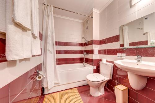 a bathroom with a toilet and a sink and a tub at Ski Slope Getaway at Grand Monastery by Flat Manаger in Pamporovo