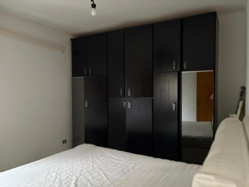 a bedroom with black cabinets and a white bed at Bartoli 8, Viserbella di Rimini in Rimini
