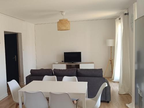 a living room with a couch and a table and chairs at Havre de paix près d'Avignon in Bédarrides
