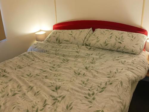 a bedroom with a bed with a red headboard at Brynowen Holiday Park - Holiday Accommodation 19041 in Borth
