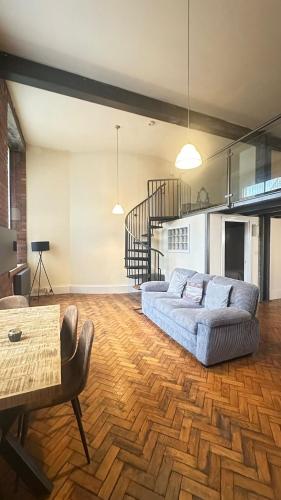 a living room with a couch and a table at Cityscape condos in Dewsbury