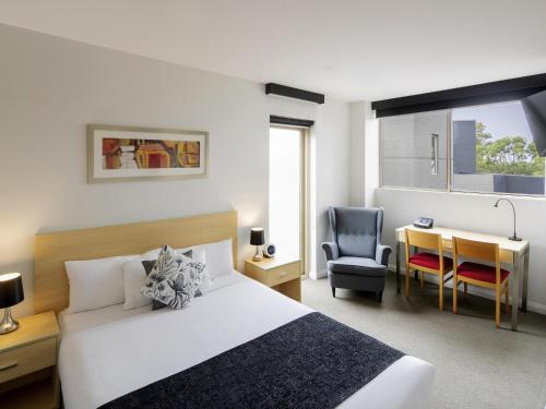 a bedroom with a bed and a desk and a chair at Mantra Castle Hill Sydney, an Accor Hotel in Castle Hill