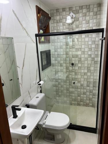 a bathroom with a toilet and a sink and a shower at Chalé com Ar Condicionado Praia Seca in Araruama
