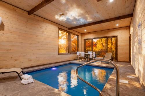 a pool in a log home with a wooden wall at Dream Chaser - Adventure Gateway in Gatlinburg