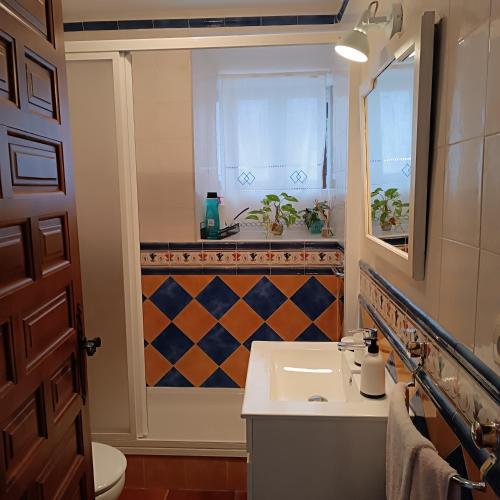 a bathroom with a sink and a mirror and a window at La Fragua de Domingo in Villanueva de los Infantes