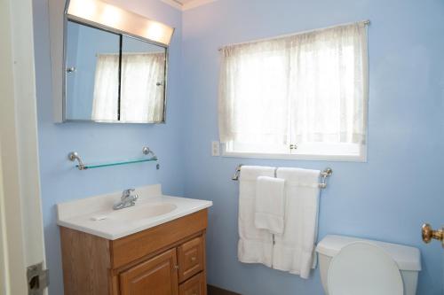 een badkamer met een wastafel, een toilet en een spiegel bij Chapala Gardens Historic West Beach 1BR - Unit 2 in Santa Barbara