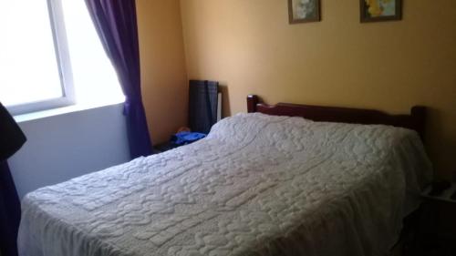 um quarto com uma cama branca com janela em Great place for summer near the sea, downtown em Capão da Canoa