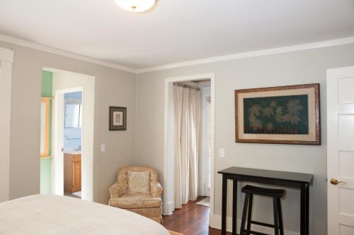 een slaapkamer met een bed, een stoel en een tafel bij Chapala Gardens Historic West Beach 1BR - Unit 2 in Santa Barbara