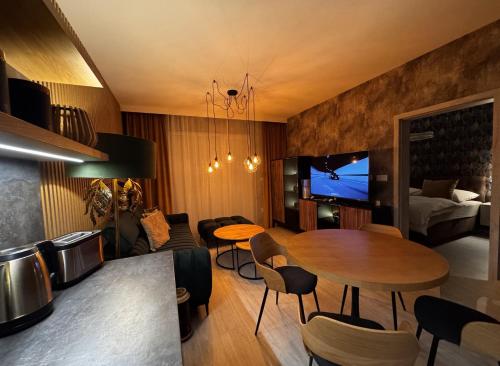 a living room with a table and a bedroom at Apartmán Lottner in Kysucké Nové Mesto