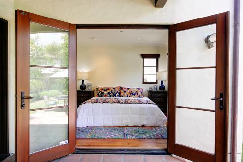 Un dormitorio con una cama y una puerta corrediza de vidrio. en West Beach Villa 5, en Santa Bárbara